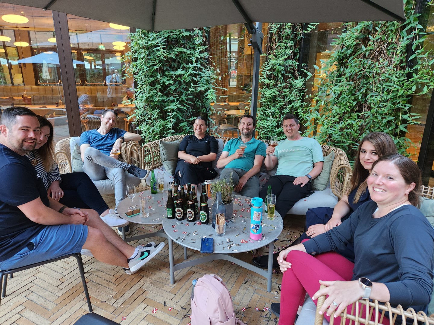 A group of people sitting at a small table outside the hotel.